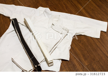 道場の床に置かれた親子の道着(空手着、柔道着)と黒帯・白帯 道場の床に置かれた親子の道着(空手着、柔道着)と黒帯・白帯 31612723