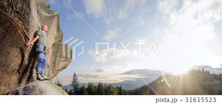 Male climber climbing big boulder with rope Male climber climbing big boulder with rope 31615523