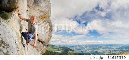 Male climber climbing big boulder with rope Male climber climbing big boulder with rope 31615530