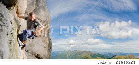 Male climber climbing big boulder with rope Male climber climbing big boulder with rope 31615531