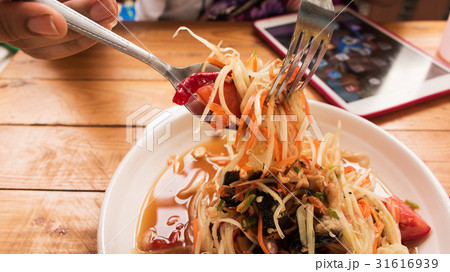 Close up of women eating spicy papaya salad Close up of women eating spicy papaya salad 31616939
