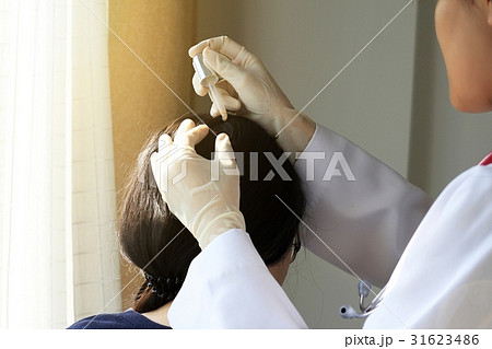 Doctor treatment at patient's hair and scalp 31623486