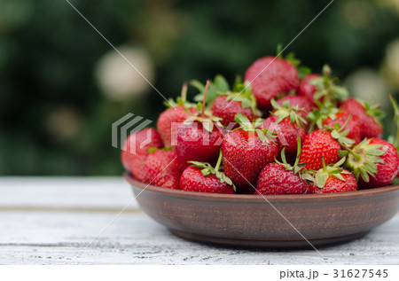 Ripe red strawberries on wooden table 31627545