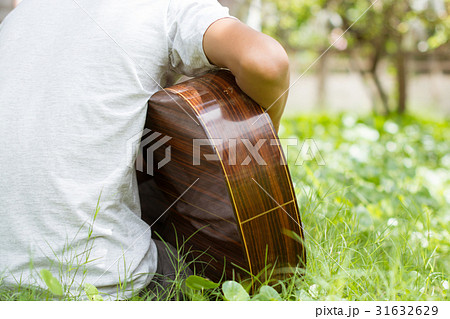 Happy young guitarist living On the lawn home. 31632629
