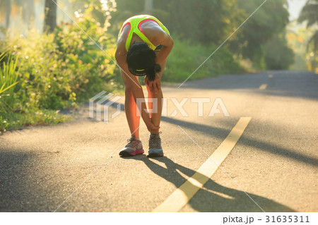 Young female runner got sports injury on knee Young female runner got sports injury on knee 31635311