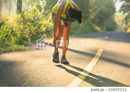 Young female runner got sports injury on knee 31635312
