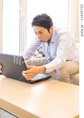 ノートパソコンをリビングで使うシーン、男性 31640797