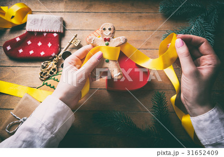 hands wrapping christmas gifts and cookies 31652409