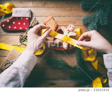 hands wrapping christmas gifts and cookies 31652410