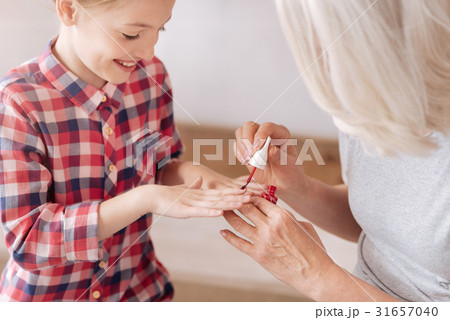 Positive delighted girl having her nails manicured 31657040