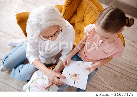 Nice happy woman looking at her granddaughters Nice happy woman looking at her granddaughters 31657175