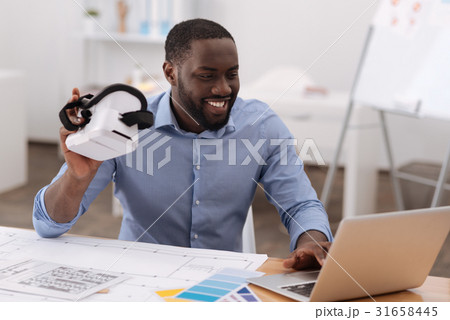 Joyful handsome man looking at the laptop screen 31658445