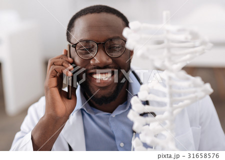 Cheerful nice scientist speaking on the phone 31658576