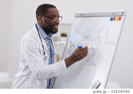 Smart cheerful scientist writing on the whiteboard Smart cheerful scientist writing on the whiteboard 31658590