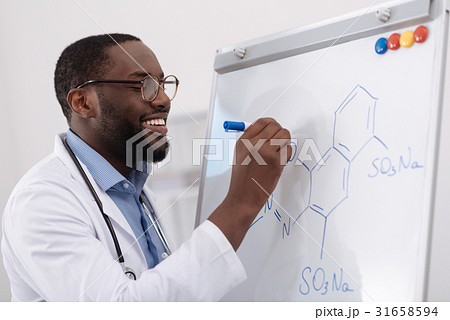 Handsome positive chemist writing a formula Handsome positive chemist writing a formula 31658594