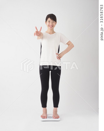 笑顔で体重を測る女性 31658763