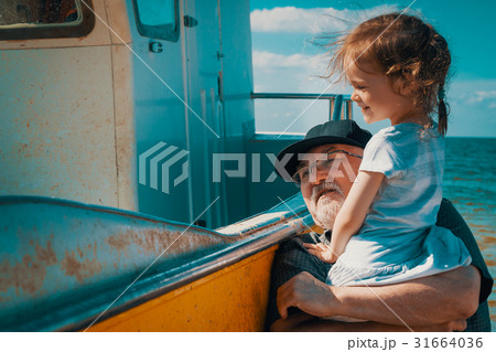 Grandfather fisherman shows granddaughter his boat Grandfather fisherman shows granddaughter his boat 31664036