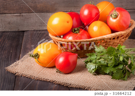 red and yellow tomatoes in a wicker basket on 31664212