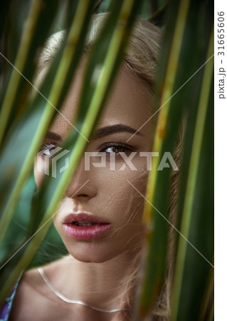 Portrait of girl on background of palm leaf Portrait of girl on background of palm leaf 31665606