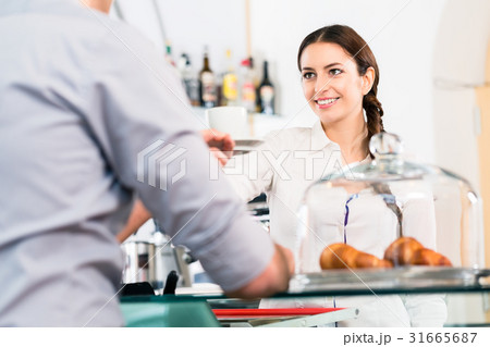 Beautiful waitress serving male customer with a Beautiful waitress serving male customer with a 31665687