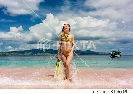 Beautiful young woman holding snorkeling equipment 31665696