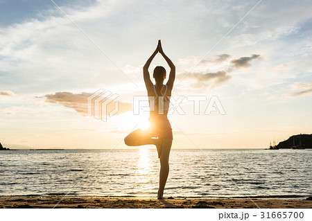 Silhouette of a woman practicing the tree yoga 31665700