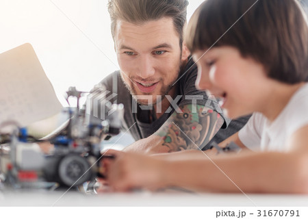 Cheerful smiling team of technicians creating toy Cheerful smiling team of technicians creating toy 31670791