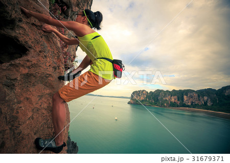 young woman rock climber climbing on cliff young woman rock climber climbing on cliff 31679371