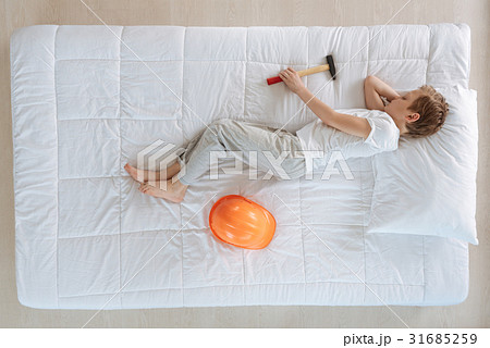 Pleasant peaceful boy holding a hammer Pleasant peaceful boy holding a hammer 31685259