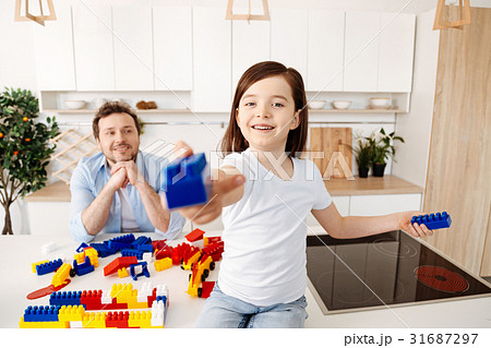 Upbeat girl holding out a construction set piece 31687297