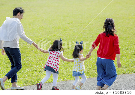 公園を歩く4人家族の後ろ姿の写真素材 公園を歩く4人家族の後ろ姿の写真素材