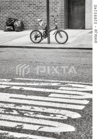 An old bicycle locked to a sign post in Chinatown. 31693140