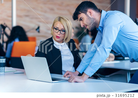 Colleagues chatting, sitting together at office 31695212