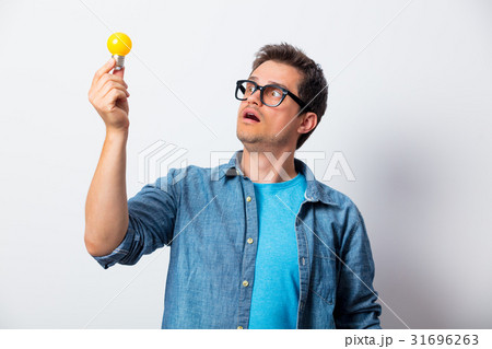 Young man in shirt holding bulb Young man in shirt holding bulb 31696263