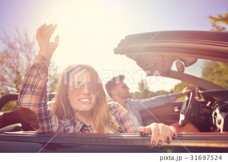 Couple of lovers driving on a convertible car - 31697524