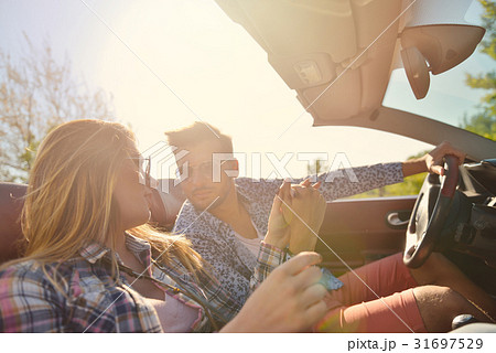 Couple of lovers driving on a convertible car - Couple of lovers driving on a convertible car - 31697529