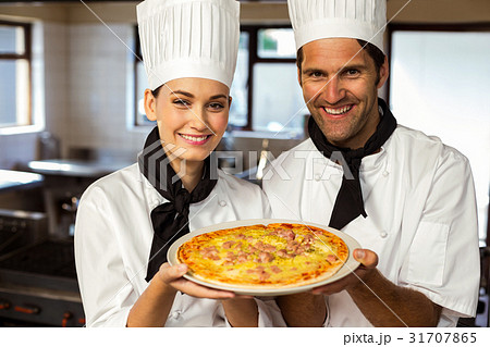 Portrait of two chef presenting a pizza 31707865