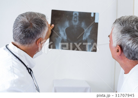 Male doctor discussing x-ray with senior man Male doctor discussing x-ray with senior man 31707945