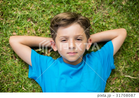 Young boy lying on grass Young boy lying on grass 31708087