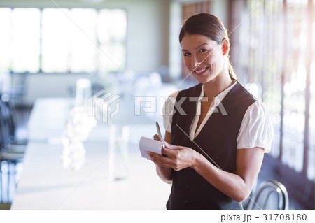 Portrait of smiling waitress taking order 31708180