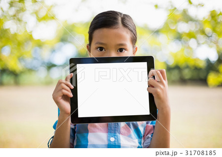 Portrait of girl showing digital tablet in park 31708185