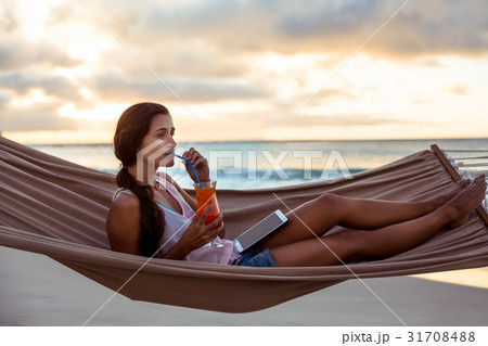 Woman having mocktail while relaxing on a hammock 31708488