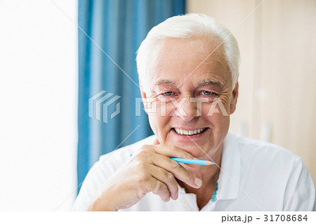 Smiling senior holding coloured pencil 31708684