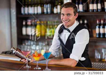 Bartender mixing a cocktail drink in cocktail shaker 31709033
