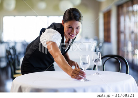 Smiling waitress setting the table 31709221