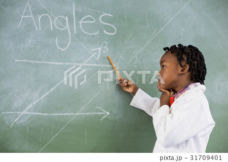 Schoolboy doing mathematics on chalkboard in classroom 31709401
