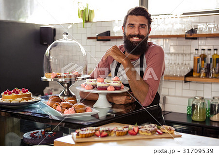 Waiter posing with cakes Waiter posing with cakes 31709539