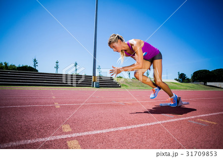 Female athlete running on the racing track Female athlete running on the racing track 31709853