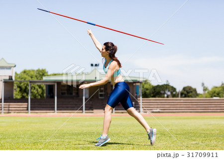 Female athlete throwing a javelin Female athlete throwing a javelin 31709911