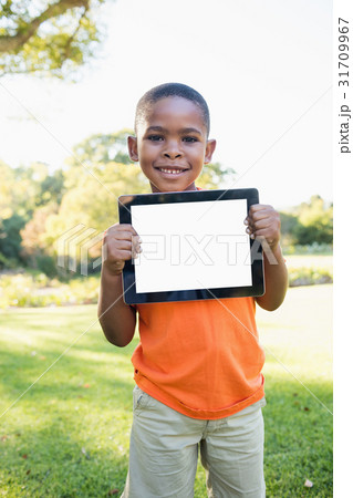 Happy child holding tablet pc while standing Happy child holding tablet pc while standing 31709967